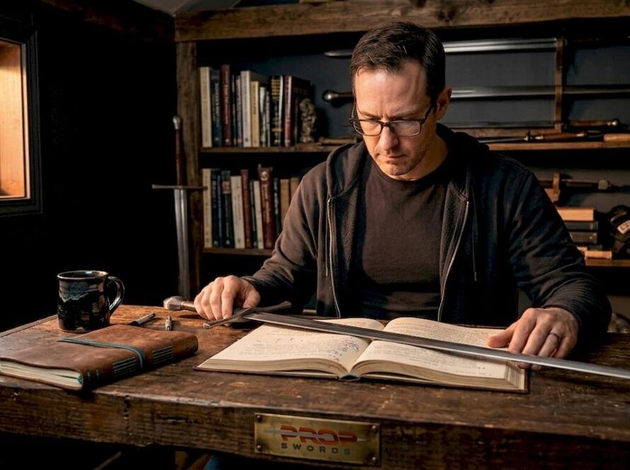HEMA practitioner studying sword manual at home