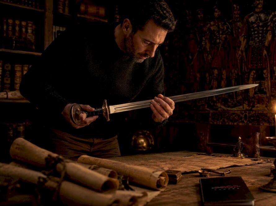 Historian examining Roman gladius sword indoors