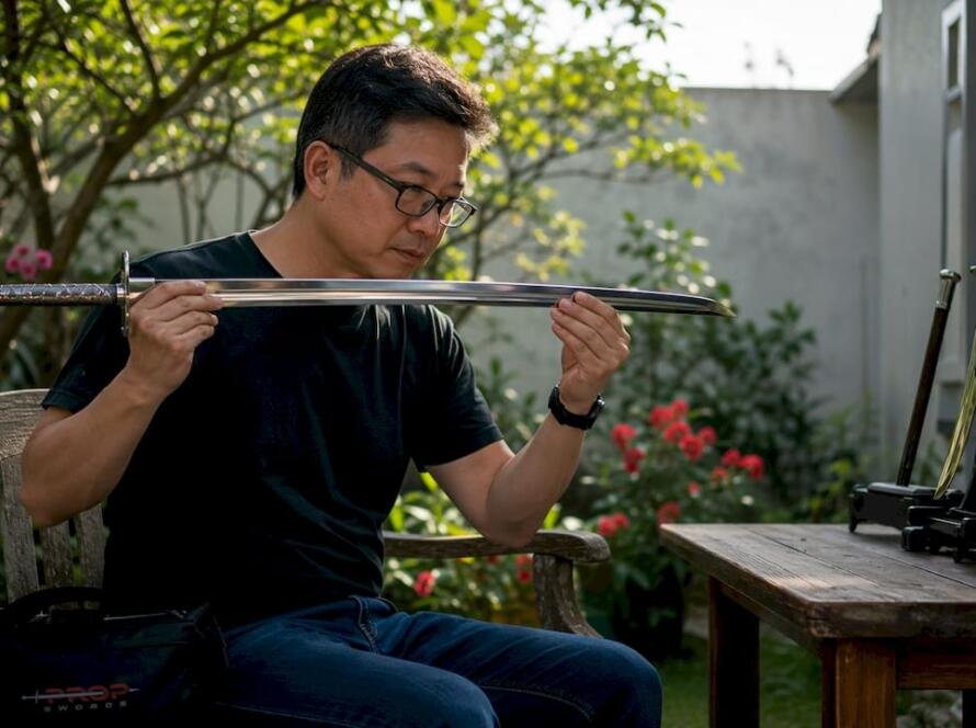 Collector inspecting stainless steel replica sword