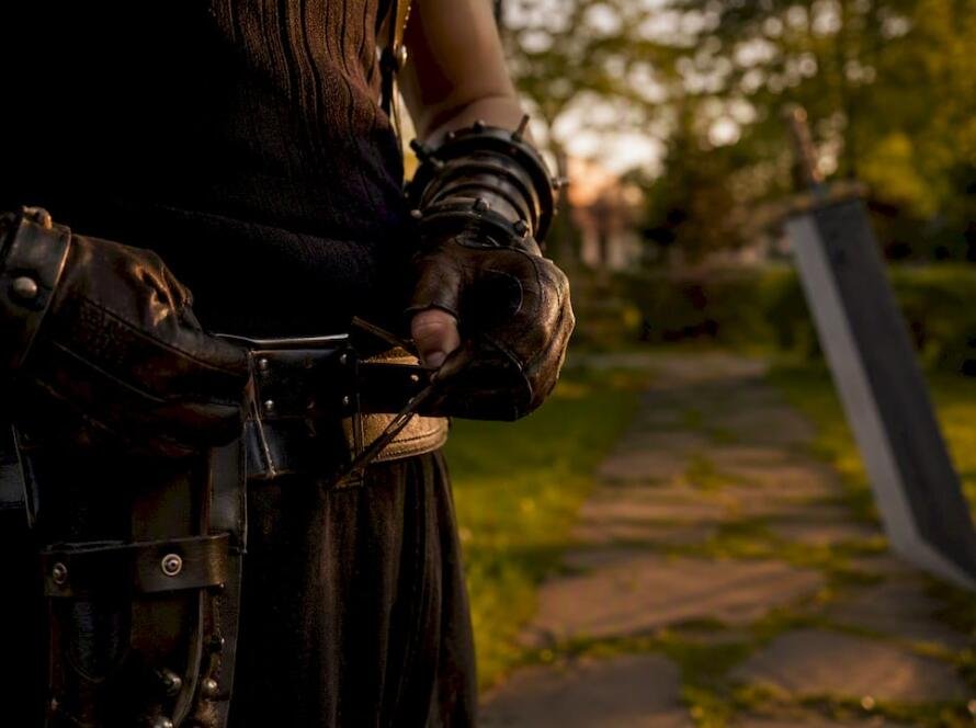 Hands adjusting cosplay sword belt outdoors